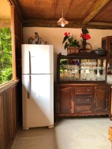 un réfrigérateur blanc dans une cuisine avec un placard dans l'établissement Eliza, Bangalô vista mar em Trancoso, à Trancoso