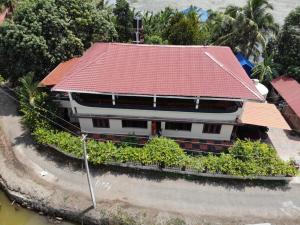 a building with a red roof on a street at Backwater Breeze in Kumarakom