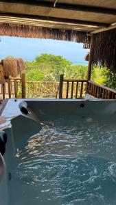 un bateau posé sur l'eau sous une maison dans l'établissement Eliza, Bangalô vista mar em Trancoso, à Trancoso