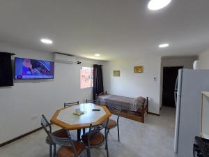 a living room with a table and a room with a bed at La Villa Inn in Villa Carlos Paz