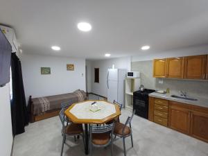 a small kitchen with a table and a bed at La Villa Inn in Villa Carlos Paz