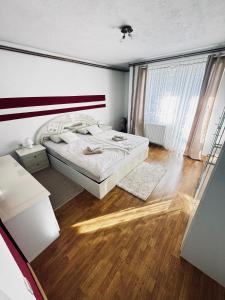een slaapkamer met een bed en een houten vloer bij Apartman Šimić in Gračac
