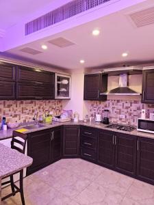 a kitchen with dark brown cabinets and a table at 2 bedrooms apartment no 13 in Amman