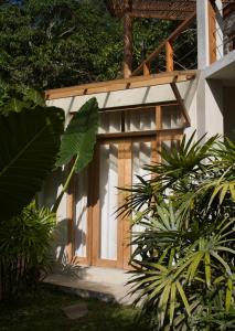 a house with a wooden door in a garden at Dannys Madiha in Kamburugamuwa
