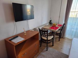 een kamer met een bureau en een televisie aan de muur bij Apartament DOM in Moşniţa Nouă