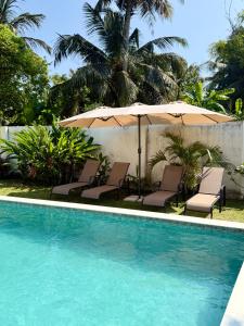 een zwembad met ligstoelen en een parasol bij Villa Carla Mirissa in Mirissa