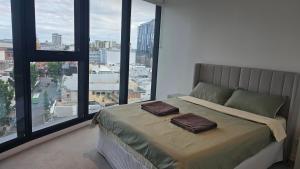 a bedroom with a bed with two brown pillows on it at FV 1BR APT with Rooftop Pool in Brisbane