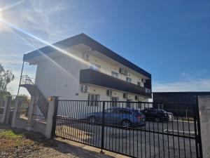 een gebouw met een auto ervoor geparkeerd bij Apartament DOM in Moşniţa Nouă
