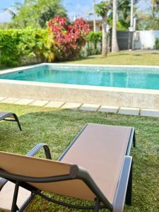 een stoel en een tafel naast een zwembad bij Villa Carla Mirissa in Mirissa +36 foto's