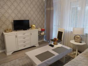 a living room with a television on a white dresser at Pokoje gościnne Słupy Olsztyn - parking in Olsztyn