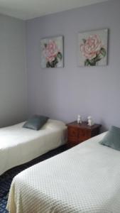 two beds in a room with two pink roses on the wall at Les chataigniers in Apremont