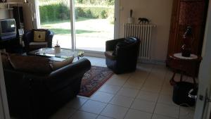 a living room with two chairs and a glass table at Les chataigniers in Apremont