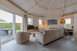 un salon avec un canapé, des chaises et une cheminée dans l'établissement Koudenburgweg 36, à Hollum