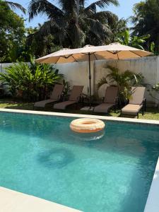 een zwembad met ligstoelen en een parasol bij Villa Carla Mirissa in Mirissa
