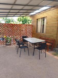 tavolo da picnic e sedie di fronte a una casa di Cabaña Puipuyen Yerbas Buenas 