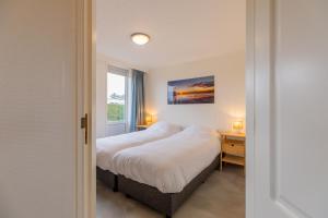 une chambre avec un lit et une fenêtre dans l'établissement Koudenburgweg 36, à Hollum