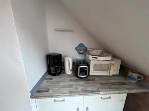 a kitchen with a counter with a microwave and appliances at Ferienwohnung für Handwerker in Kappeln +1 photo