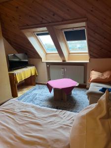 Cette chambre mansardée comprend un lit et une fenêtre. dans l'établissement Ferienwohnung für Handwerker, à Kappeln
