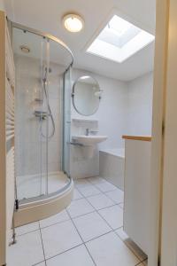 une salle de bain avec douche et lavabo dans l'établissement Koudenburgweg 36, à Hollum