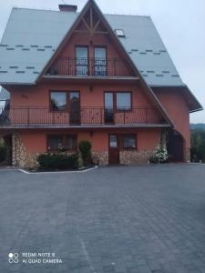 een groot rood huis met een balkon en een oprit bij Pokoje Ewka in Czarna Góra +28 foto's