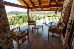 a porch with chairs and a table on a balcony at Hanul Mariei in Livezile