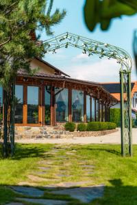 an arbor in front of a building at Hanul Mariei in Livezile +8 photos