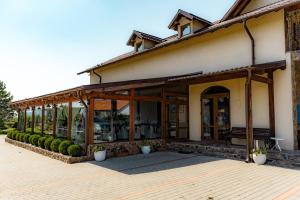 a building with large glass doors and a patio at Hanul Mariei in Livezile