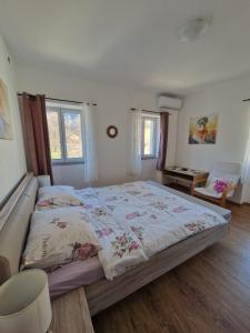 een slaapkamer met een groot bed en twee ramen bij Lukari Vacation Home in Drivenik
