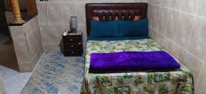 een slaapkamer met een bed met een paars dekbed bij Airport Agadir Guest House in Agadir