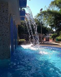 a fountain in the middle of a swimming pool at Refúgio das Thermas in Caldas Novas