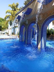 a water fountain in the middle of a swimming pool at Refúgio das Thermas in Caldas Novas