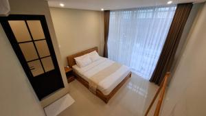 a small bedroom with a bed and a window at Kalih Rooms in Ubud +5 photos