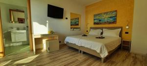 een slaapkamer met een bed en een tv aan de muur bij Appartamenti Villa Eden in Malcesine