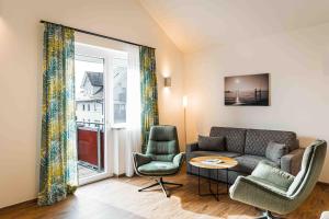 een woonkamer met een bank en twee stoelen bij Hotel Lipprandt in Wasserburg
