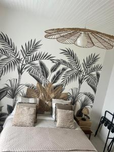 een slaapkamer met een muurschildering van palmbomen aan de muur bij Charmant logement avec 2 véranda in Le Vivier-sur-Mer