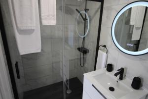 a bathroom with a shower and a sink and a mirror at O Cantinho D'Alice in Sabugal +7 photos