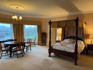 una camera con letto a baldacchino e tavolo e sedie di Netley Hall a Shrewsbury Altre 53 foto