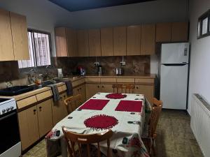 a kitchen with a table and a white refrigerator at ARTEMIS HOUSe in Kakopetria
