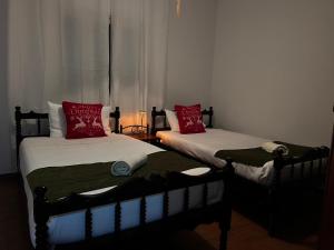 two twin beds with red pillows in a room at ARTEMIS HOUSe in Kakopetria +11 photos
