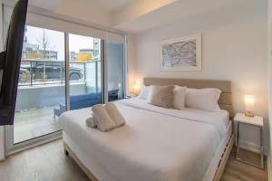 een slaapkamer met een groot wit bed en een groot raam bij PET FRIENDLY CONDOS at FRIDAY HARBOUR in Innisfil +102 foto's