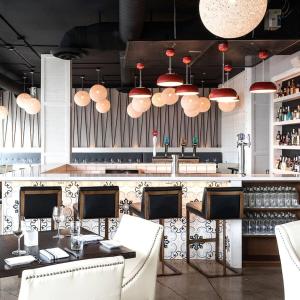 een restaurant met een tafel en stoelen en hanglampen bij PET FRIENDLY CONDOS at FRIDAY HARBOUR in Innisfil