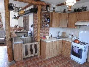 una cucina con armadi in legno e un piano cottura bianco con forno di Agroturystyka Biebrzańska Kraina a Pluty