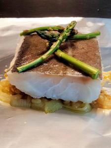 een stuk vis met asperges op een wit bord bij Monte das Estrelas in Tavira