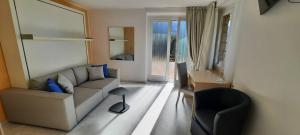 a living room with a couch and a chair at Appartamenti Villa Eden in Malcesine