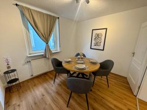 a dining room with a wooden table and chairs at Apartment SeeZeit - Top Lage & nahe am Bodensee in Friedrichshafen