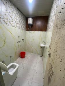 ein Badezimmer mit Toilette und Waschbecken in der Unterkunft Shri Ladli Ji Guest House in Chhatikara