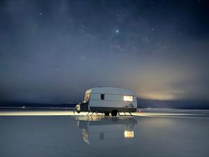 a white camper van parked on a field at night at Camper Elegance Uyuni - All Inclusive in Carpas +58 photos