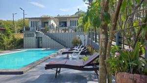 a swimming pool with lounge chairs next to a house at Samati Best House - Pool Apartments A1 - Klong Ning Beach in Ko Lanta Yai