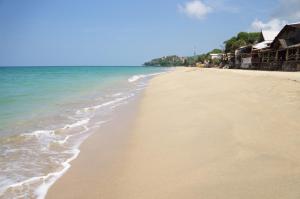 a sandy beach with the ocean and houses on it at Samati Best House - Pool Apartments A1 - Klong Ning Beach in Ko Lanta Yai