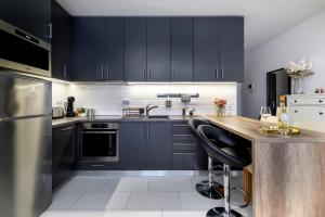 een keuken met zwarte kasten en een houten aanrecht bij Leonardo50 Apartment in Boedapest